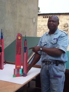 Photograph of the artist Bodys Isek Kingelez next to one of his architectural models.